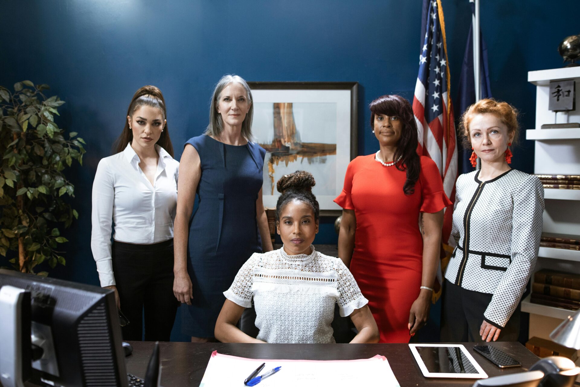 A diverse group of empowered businesswomen posing confidently in a professional office setting.