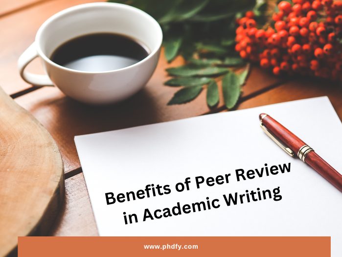 coffee cup, desk, red flowers, red pen on the paper that written benefits of peer review in academic writing