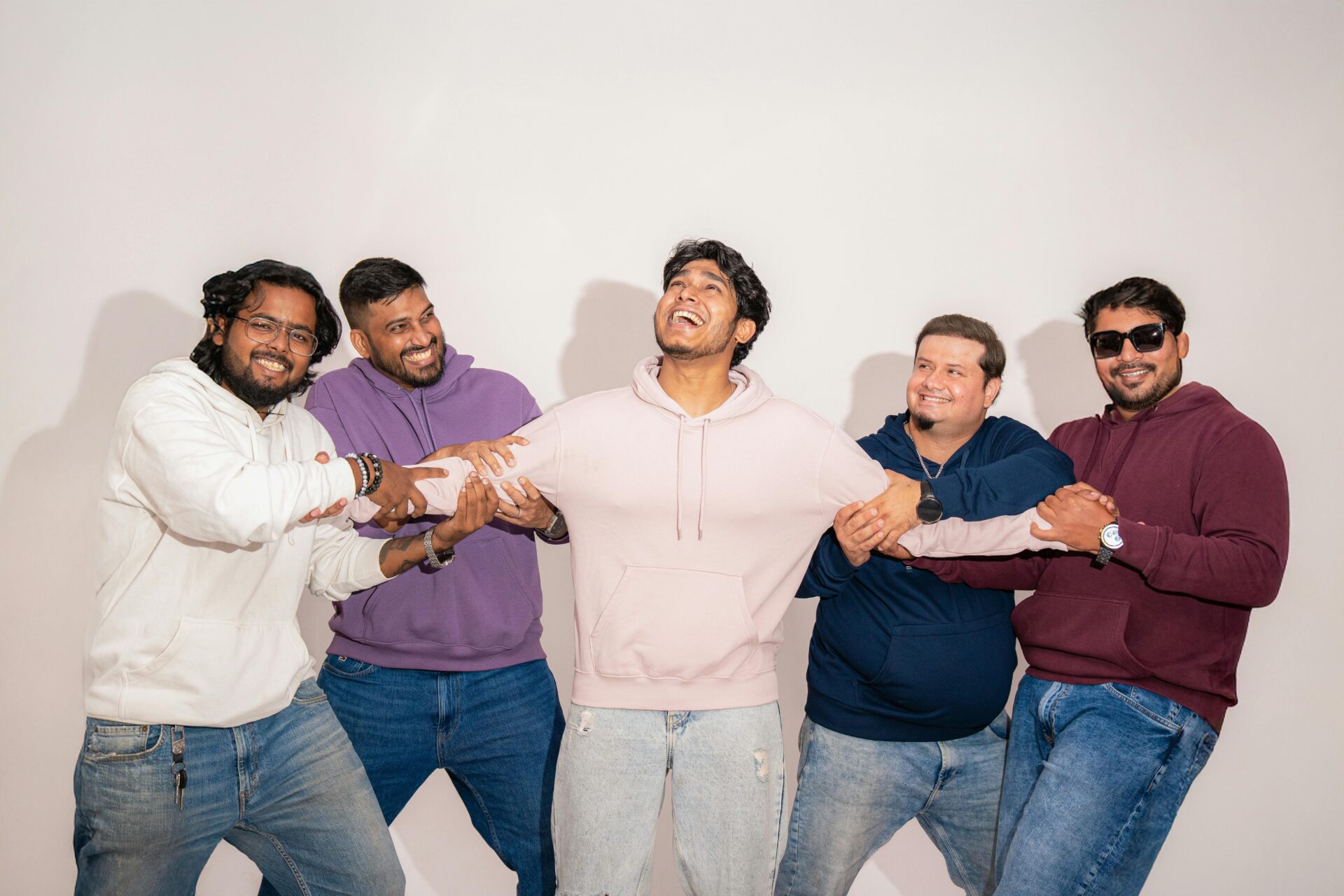 Five friends having fun in a colorful studio portrait, showcasing friendship and joy.