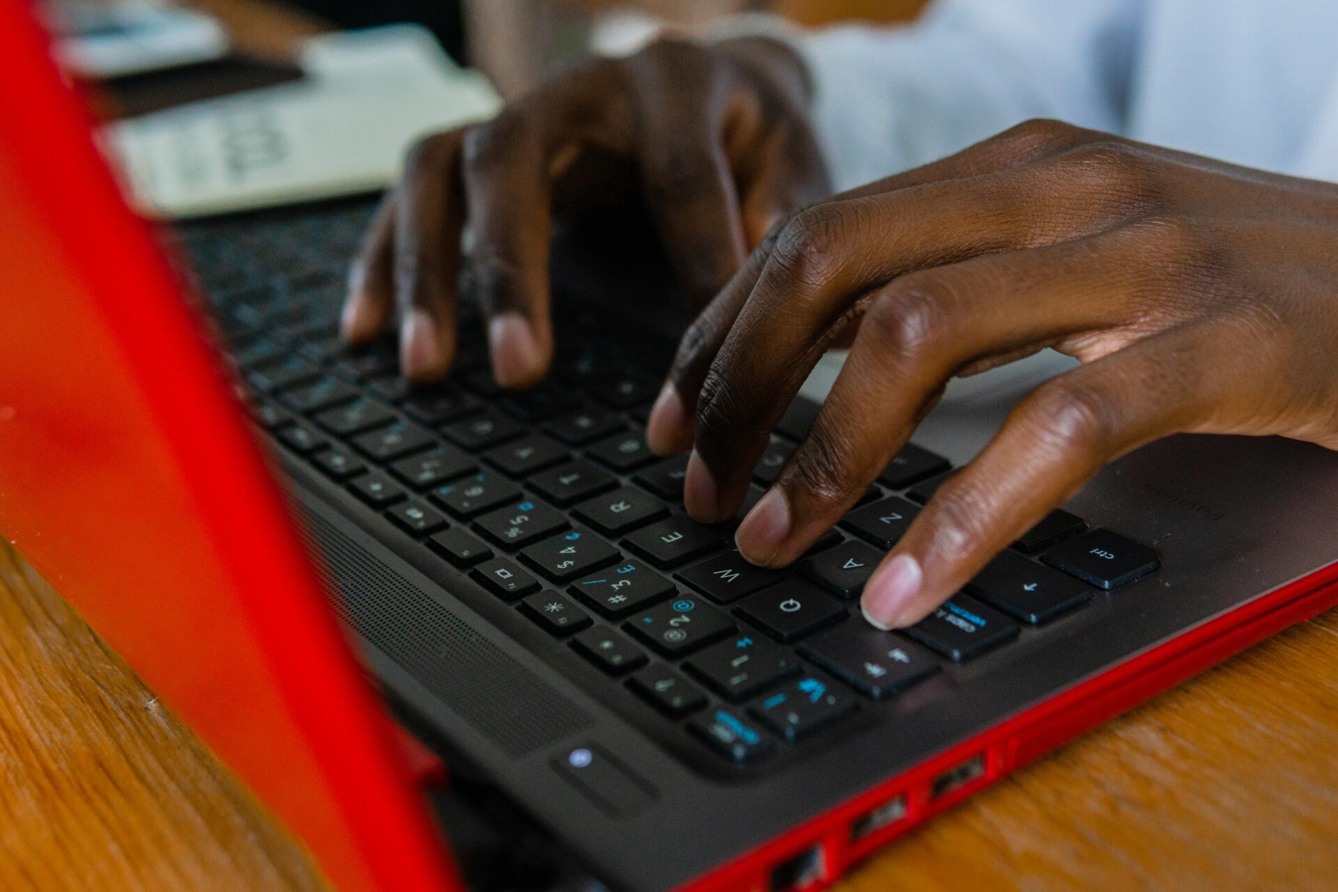 A detailed shot of hands typing on a laptop keyboard, highlighting tech engagement.