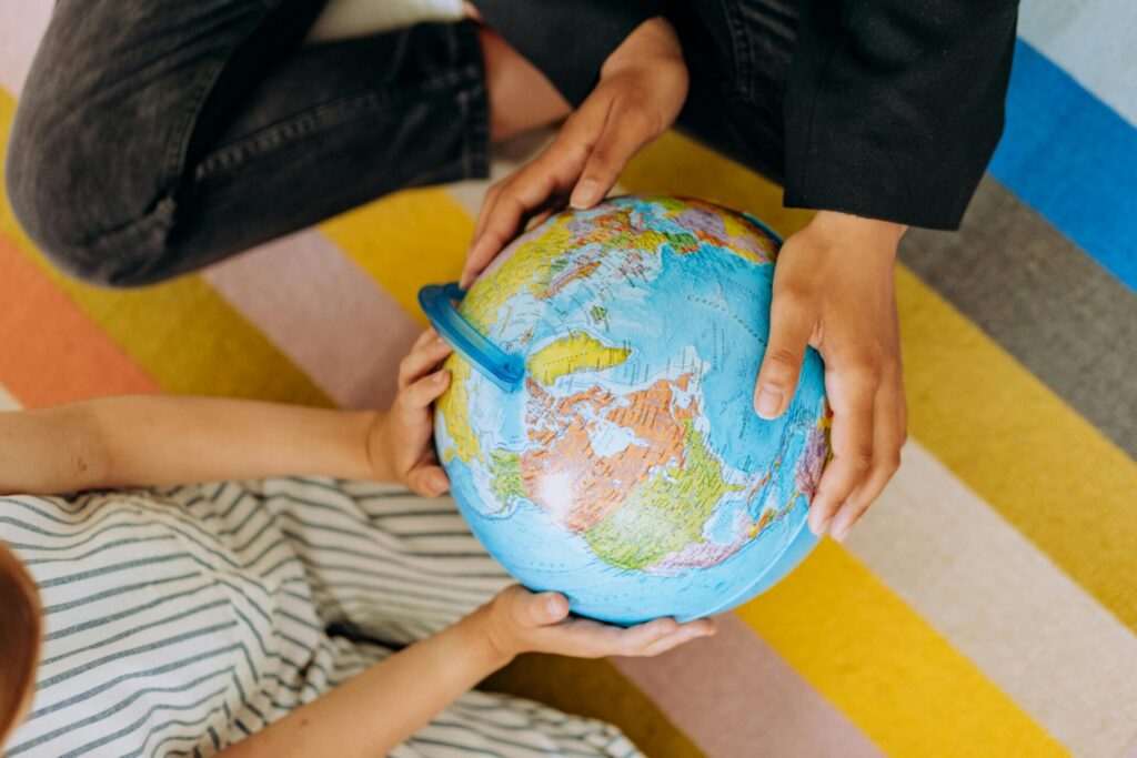 Two children exploring a colorful globe, focusing on geography education.